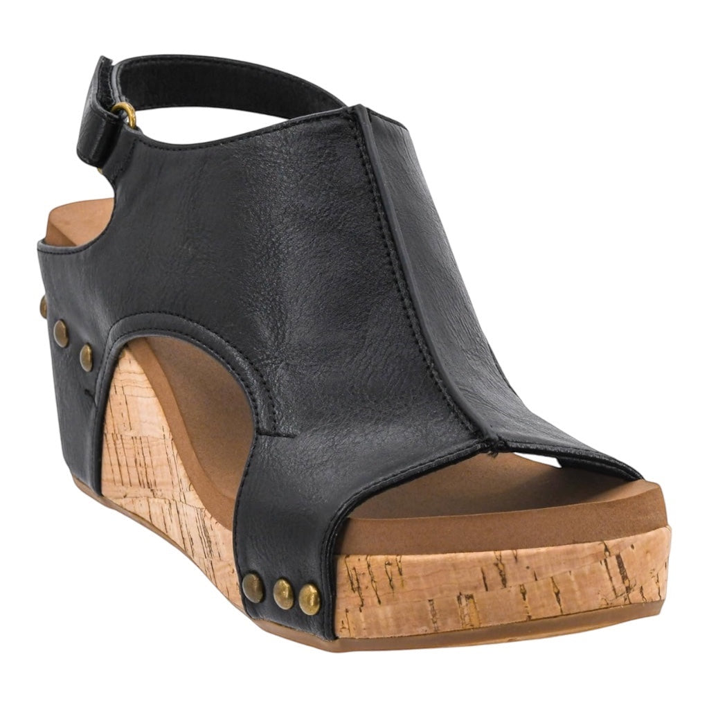 Heel Yeah Boutique Carly wedge sandal in black leather with a cork-textured platform and decorative metal studs.