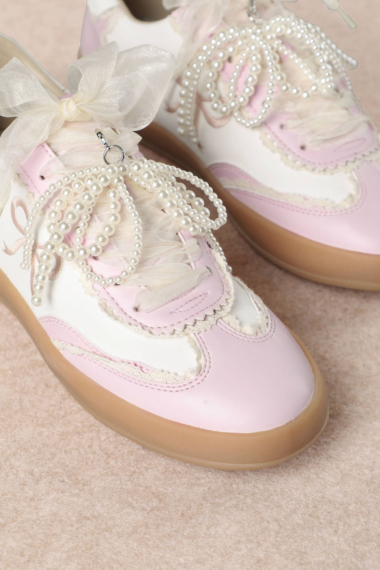 Heel Yeah Boutique Julie cream and pink sneakers with sheer ribbon laces, pearl strands, and embroidered bow details.