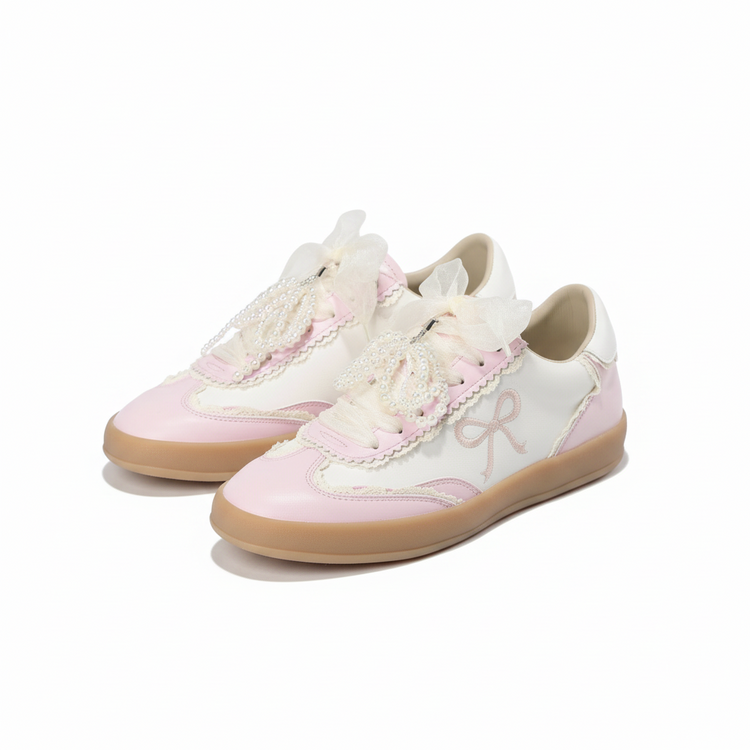 Heel Yeah Boutique Julie cream and pink sneakers with sheer ribbon laces, pearl accents, and embroidered bow motifs.
