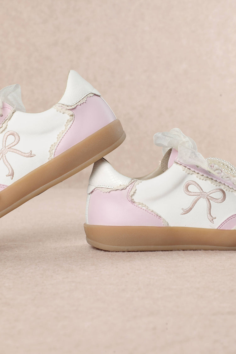 Heel Yeah Boutique Julie cream and pink sneakers featuring sheer ribbon laces, pearl accents, and embroidered bows.