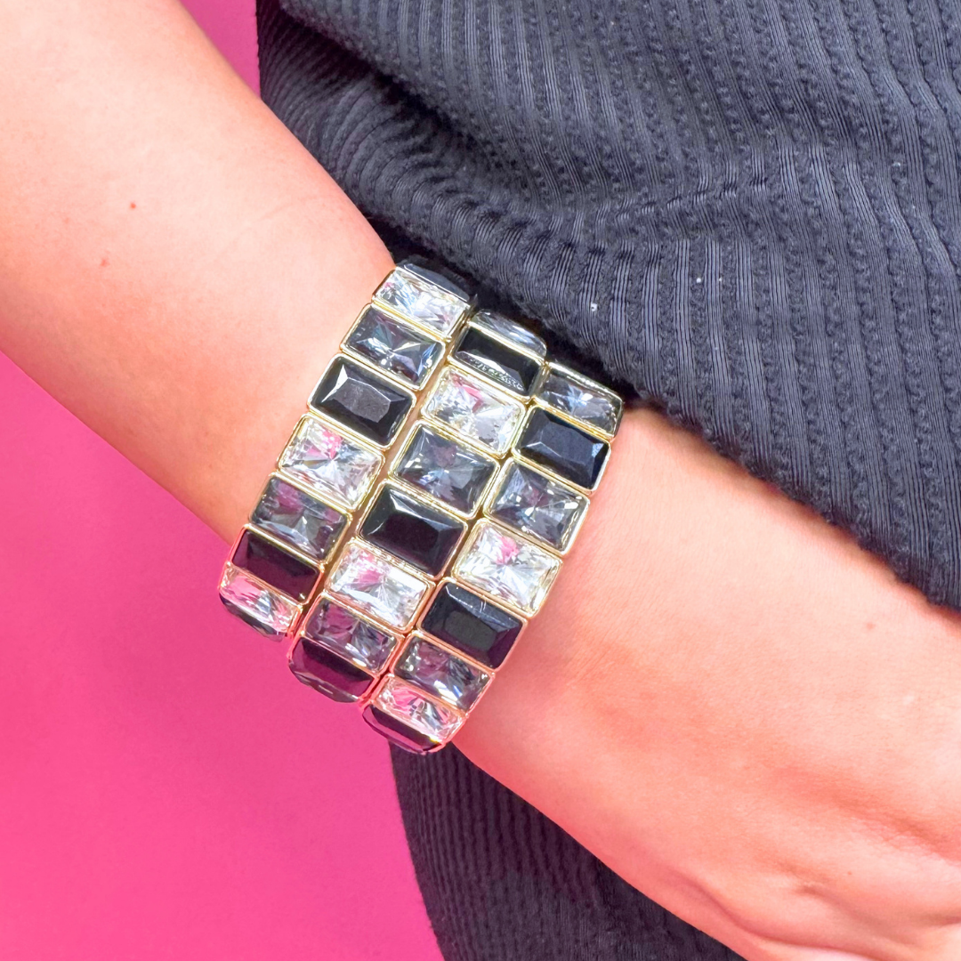 Heel Yeah Boutique Misty bangle bracelet featuring alternating black and clear rectangular crystals in gold settings.